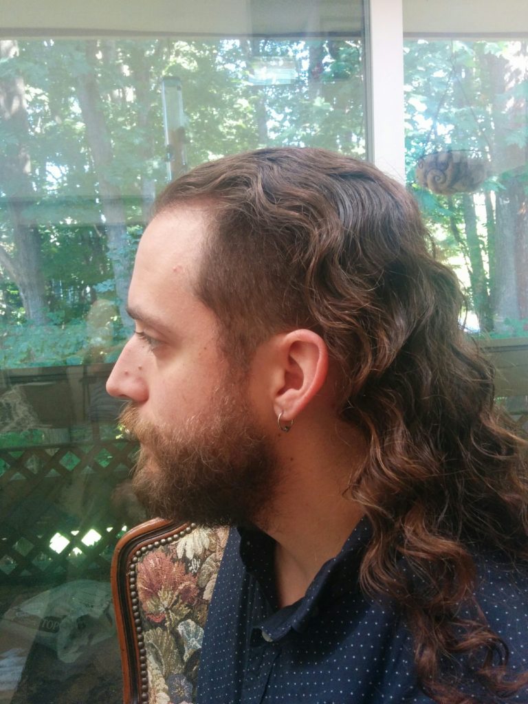 Ian facing to the left, showing how his hair is shaved close on the sides and is still long up top.